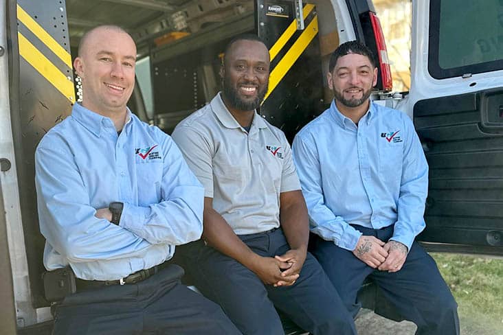 3 technicians sitting in the back of a van smiling 3 technicians sitting in the back of a van smiling
