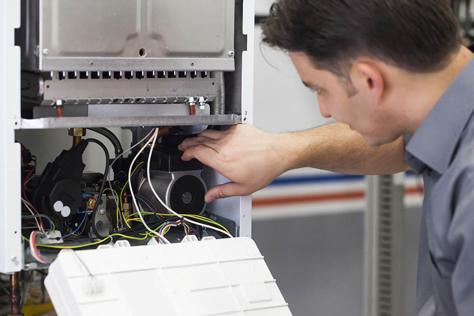 Technician servicing heating boiler HVAC technician servicing heating boiler