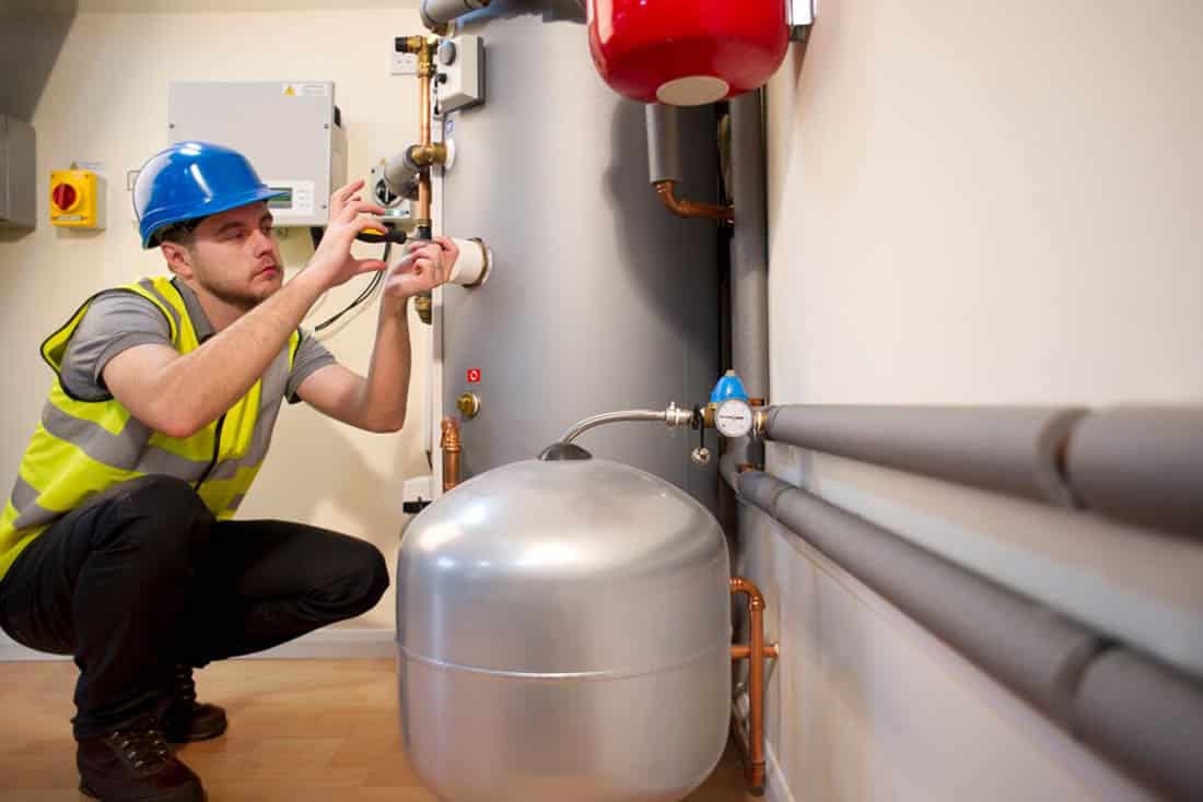 Hot Water Heaters and Boilers 8 Service technician performing maintenance service on a tank water heater